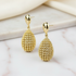 Gold droplet earrings on marble