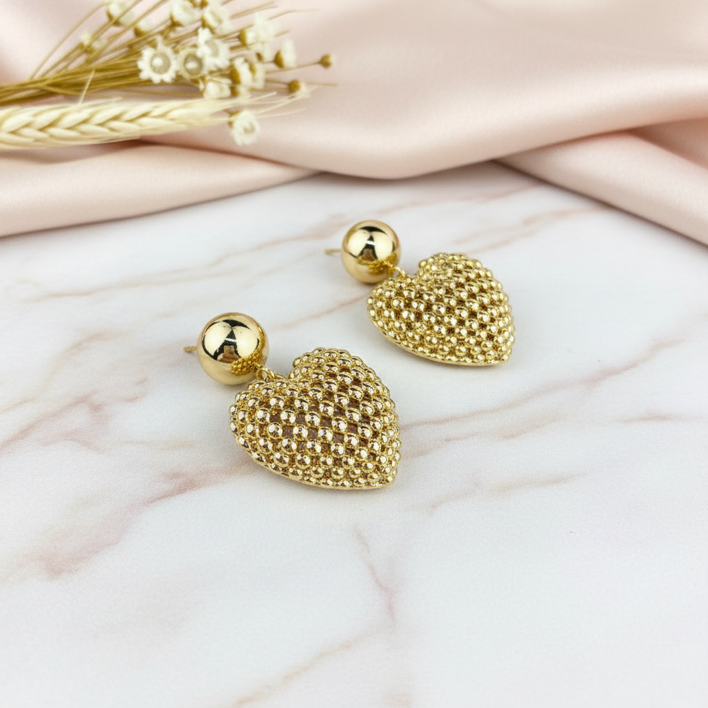 Gold heart earrings on marble