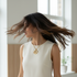Gold spiral necklace worn by model in motion