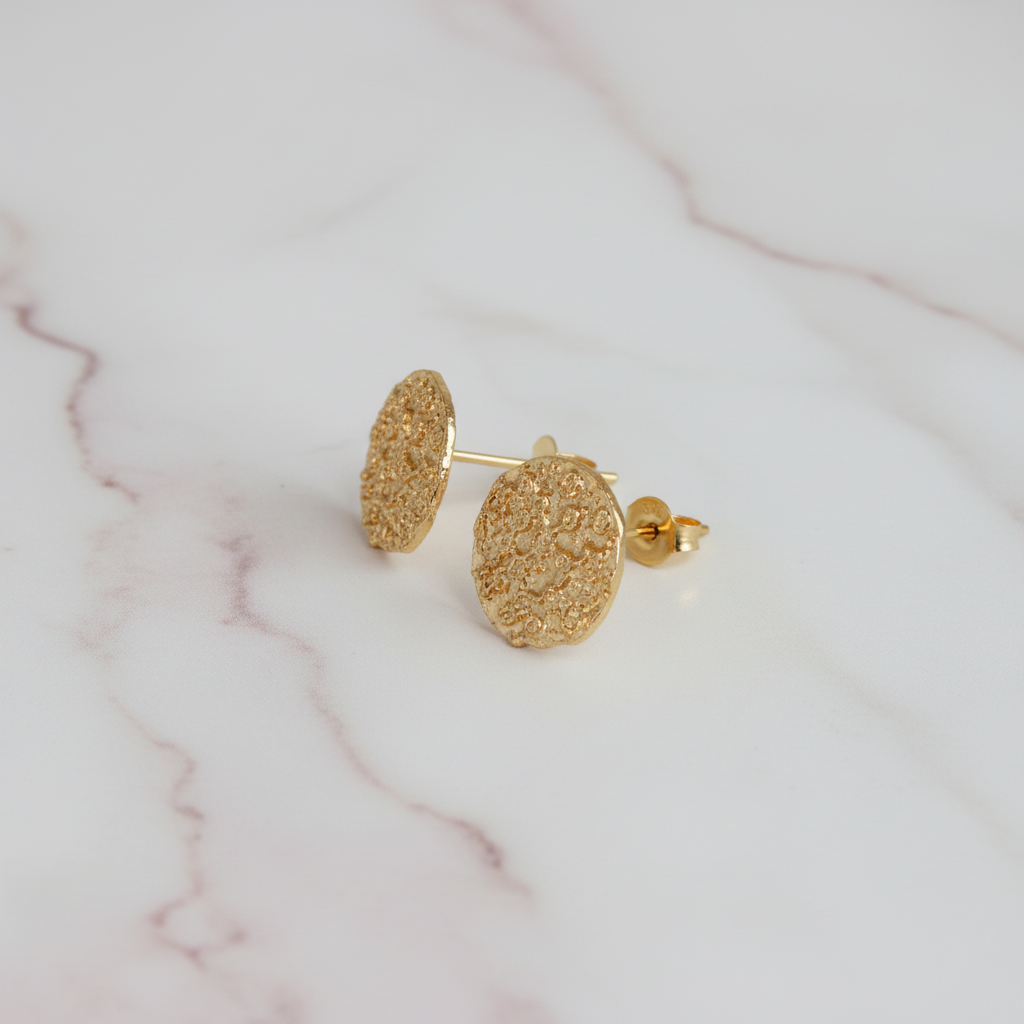 Gold textured circle studs on marble