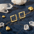 Luxury gold square studs on blue marble