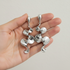 Silver sculptural earrings in hand