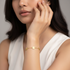 Square format model wearing gold flower bracelet