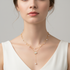 Square format model wearing layered vintage necklace